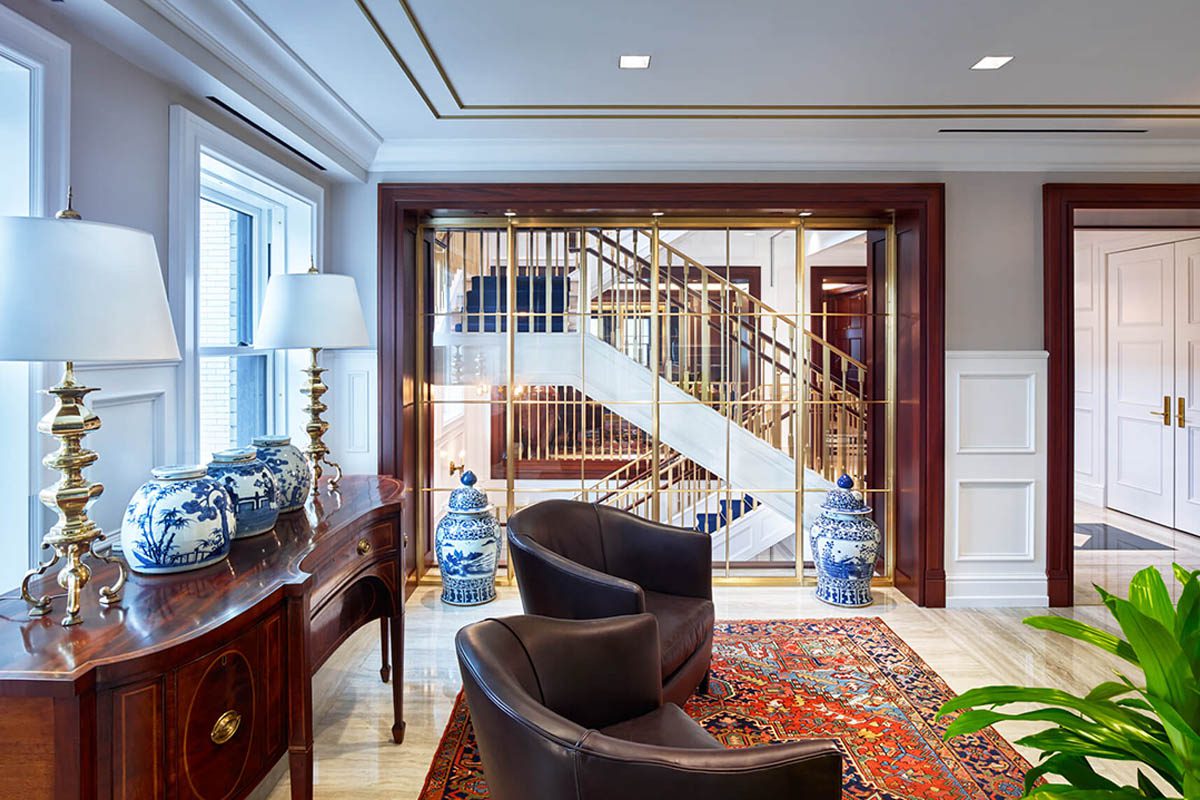Elegant living room with wooden staircase and classic decor.
