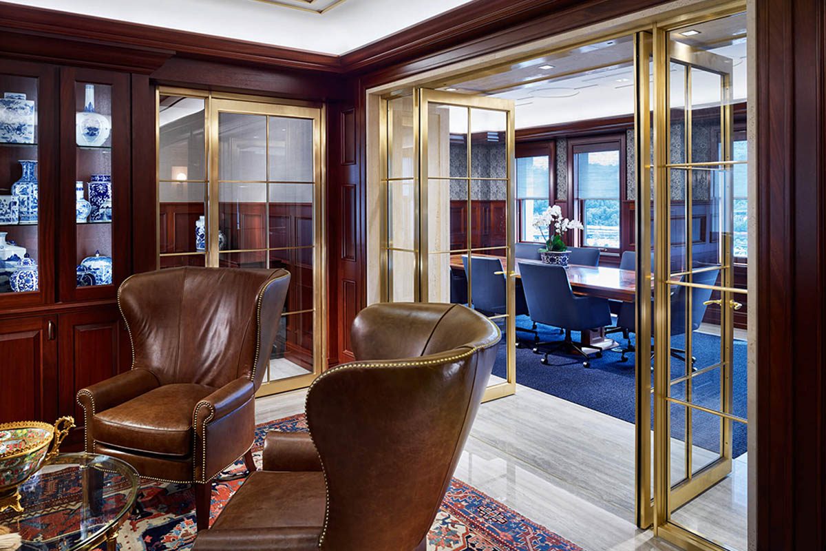 Luxurious office with leather chairs and glass partitions.