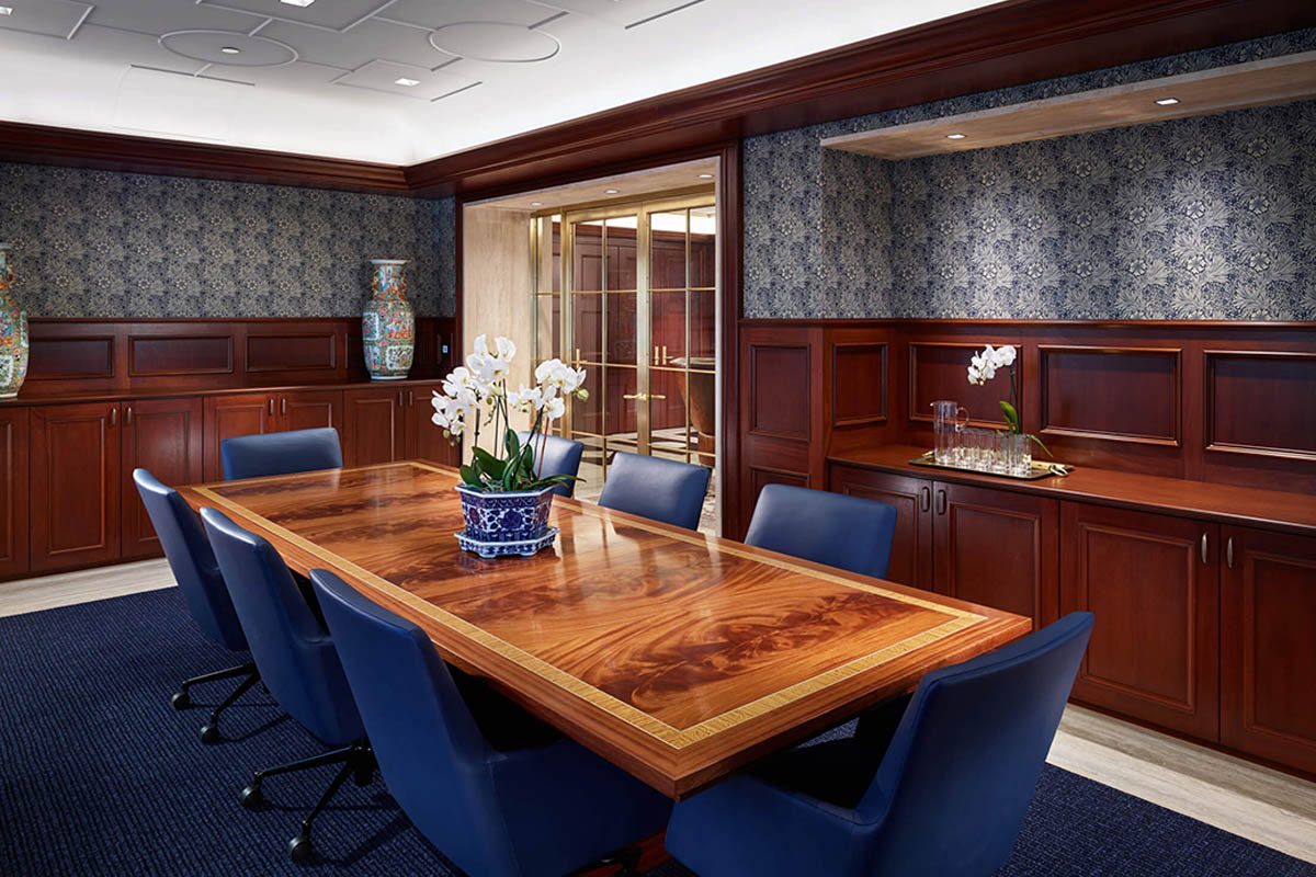 Elegant conference room with wooden table and blue chairs.