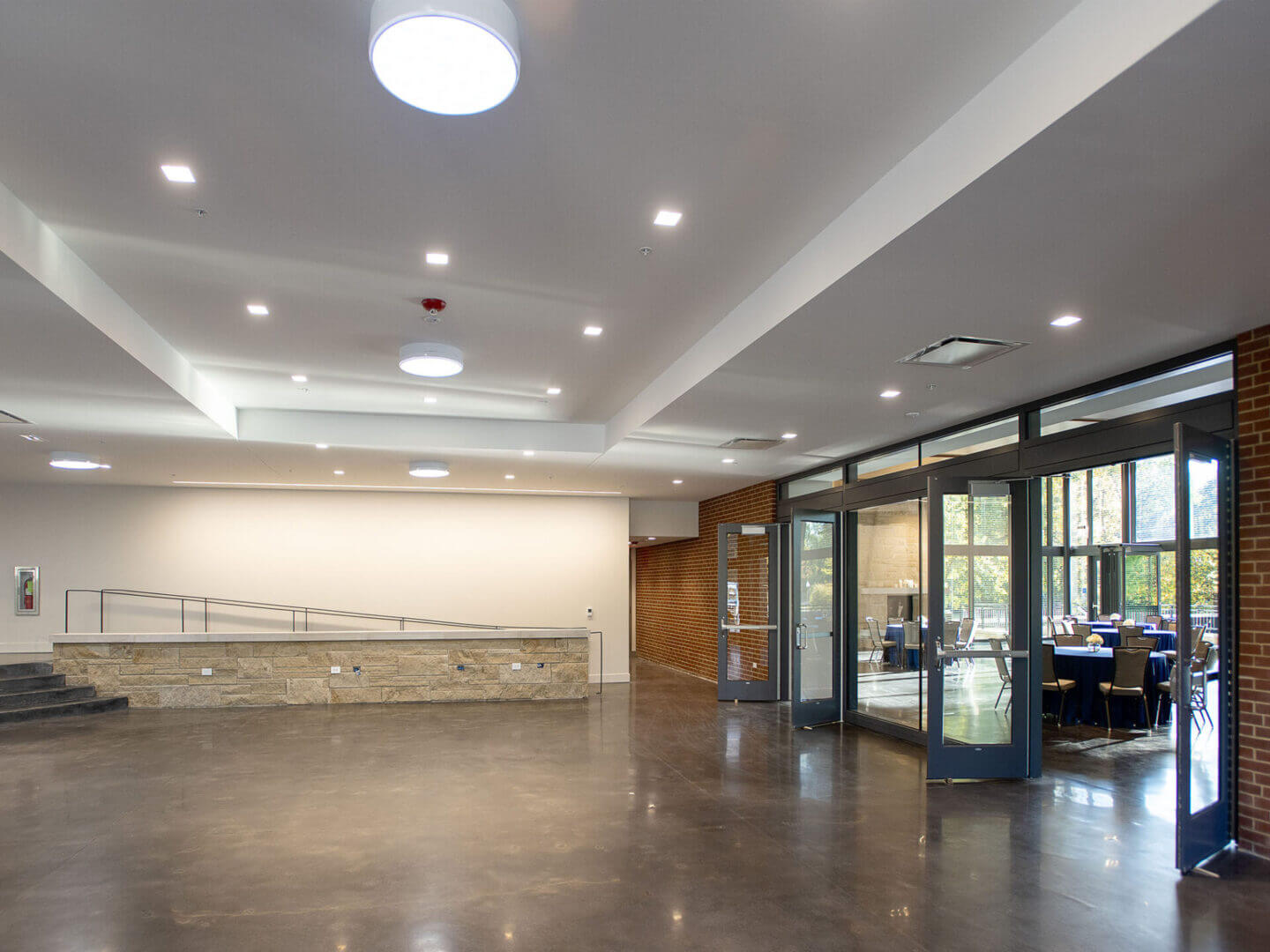 A spacious, empty lobby with polished floors and ceiling lights.