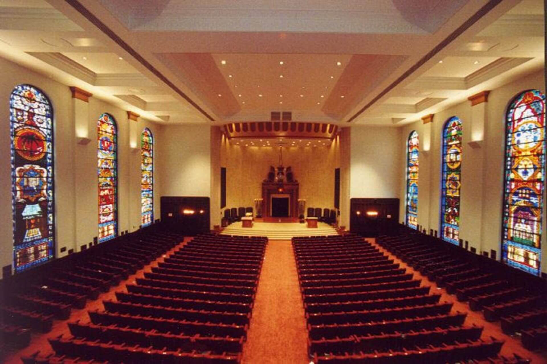 Interior of a large church with stained glass windows and a central aisle.