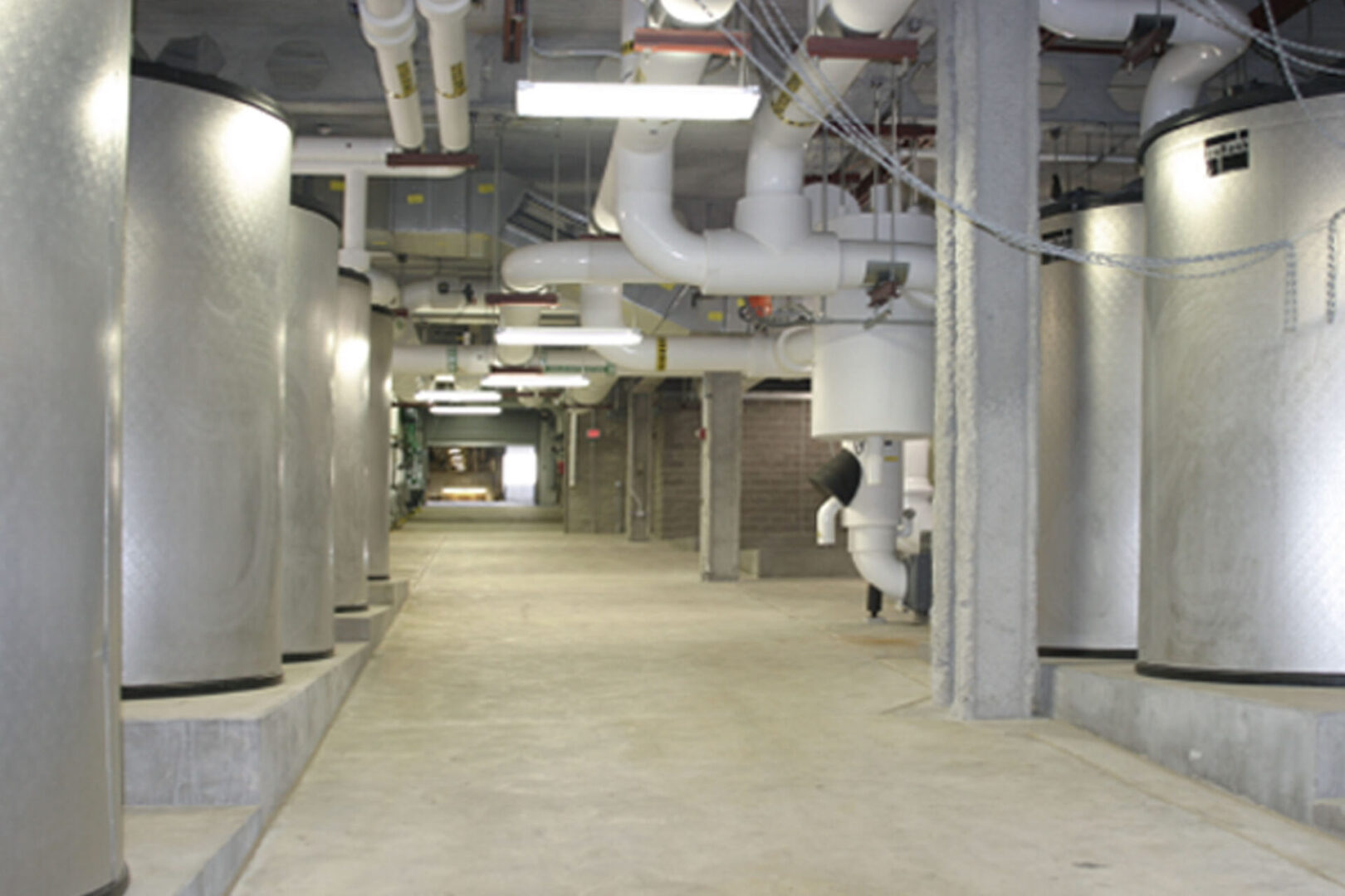 Industrial basement with pipes and concrete floor.