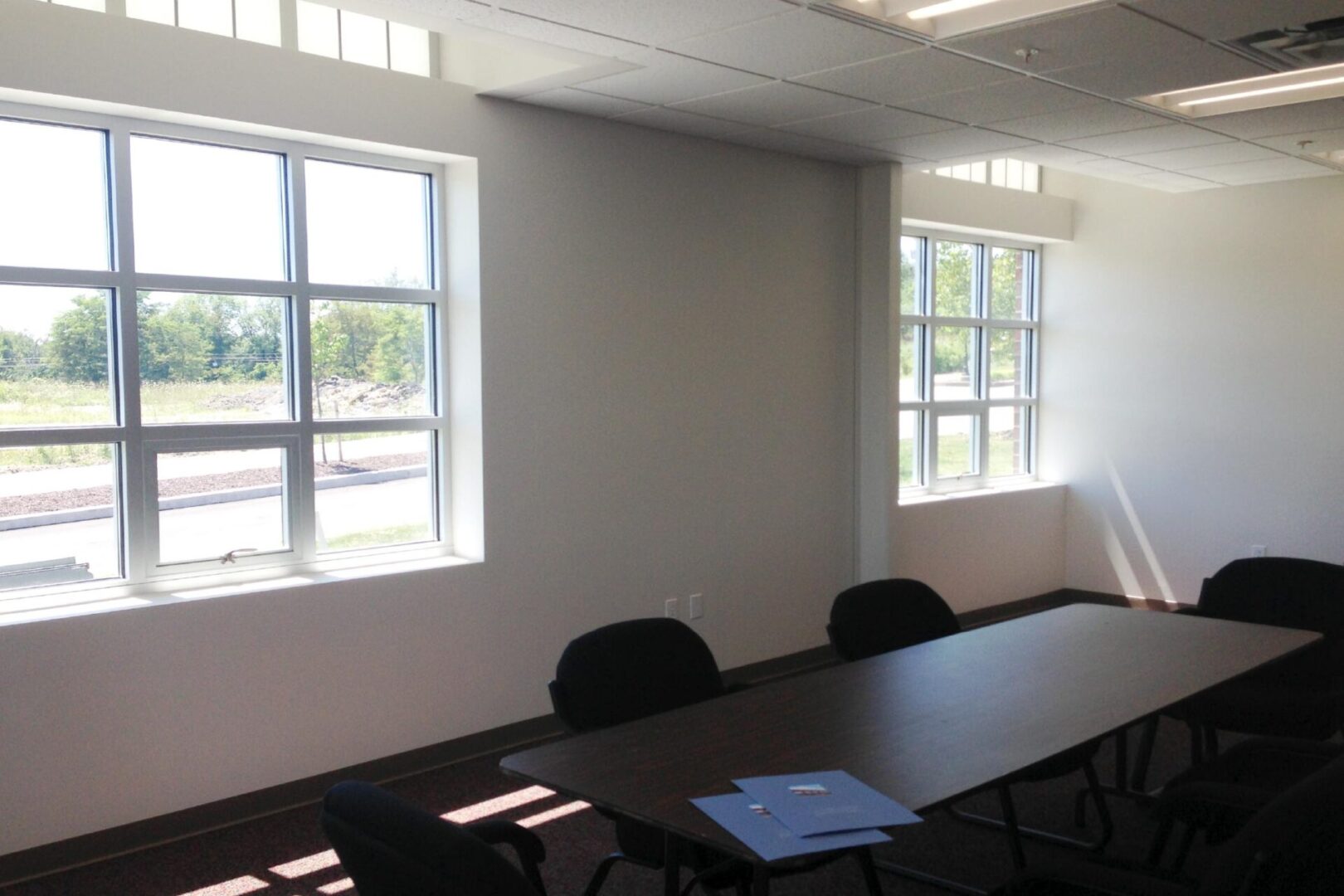 A small conference room with a table and chairs by windows.