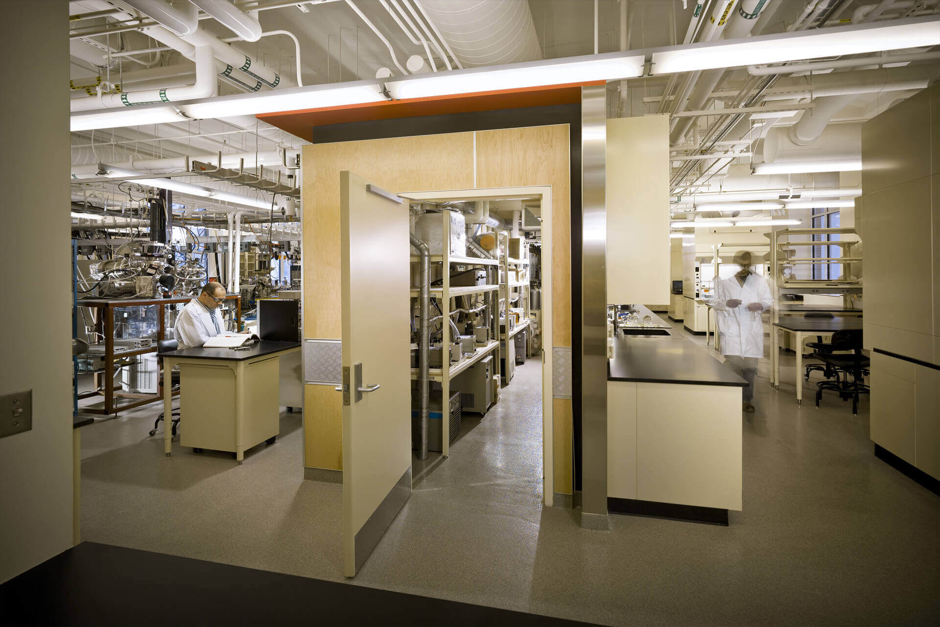 A modern laboratory with glassware and equipment on shelves and benches.