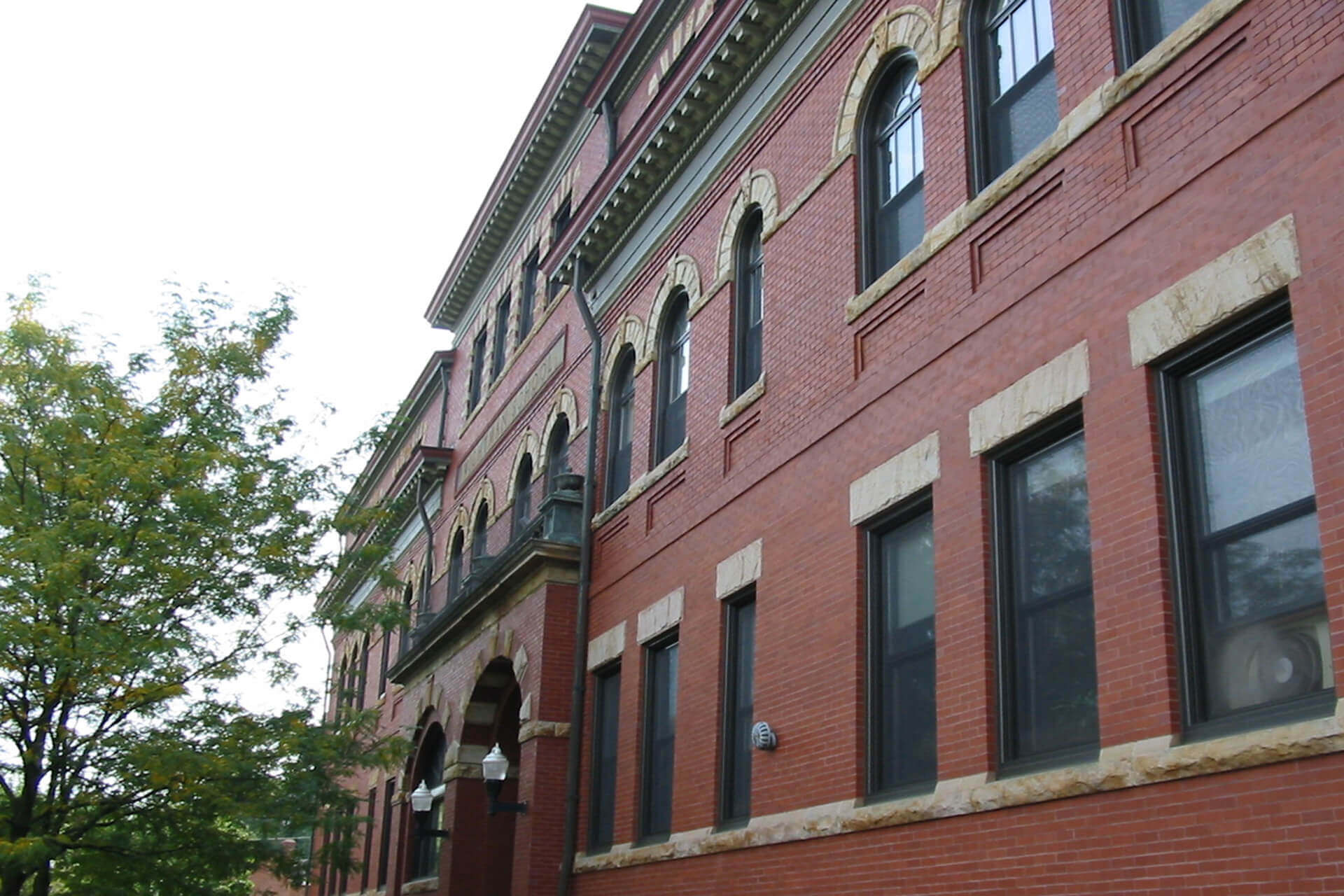 Red brick building with arched windows and stone accents.