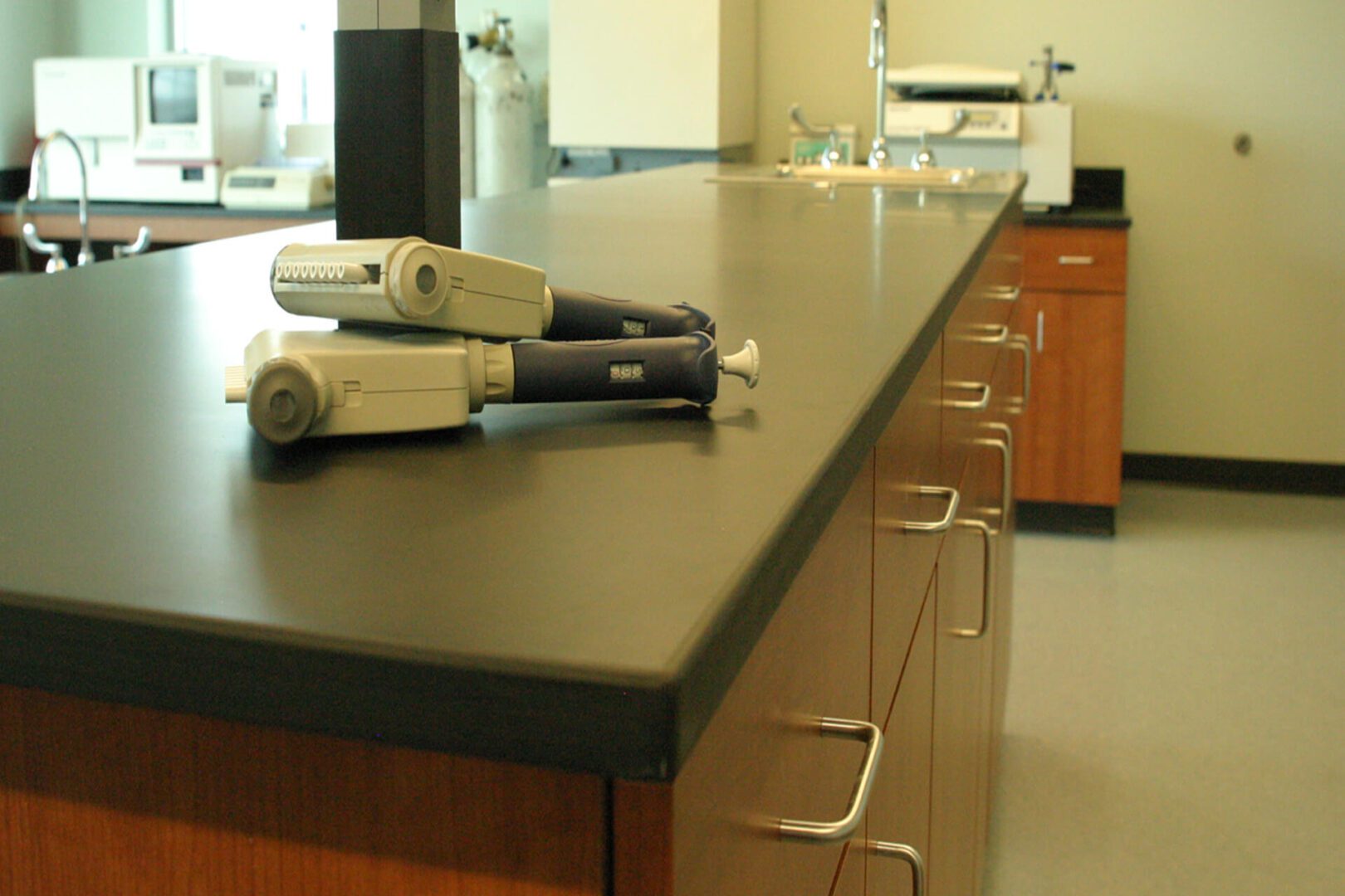 Laboratory pipettes placed on a black lab countertop.
