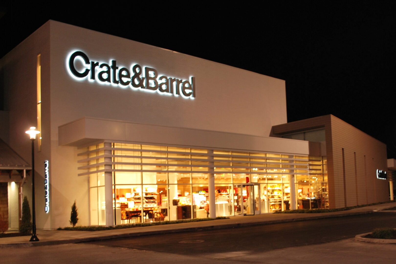 Crate & Barrel store illuminated at night.