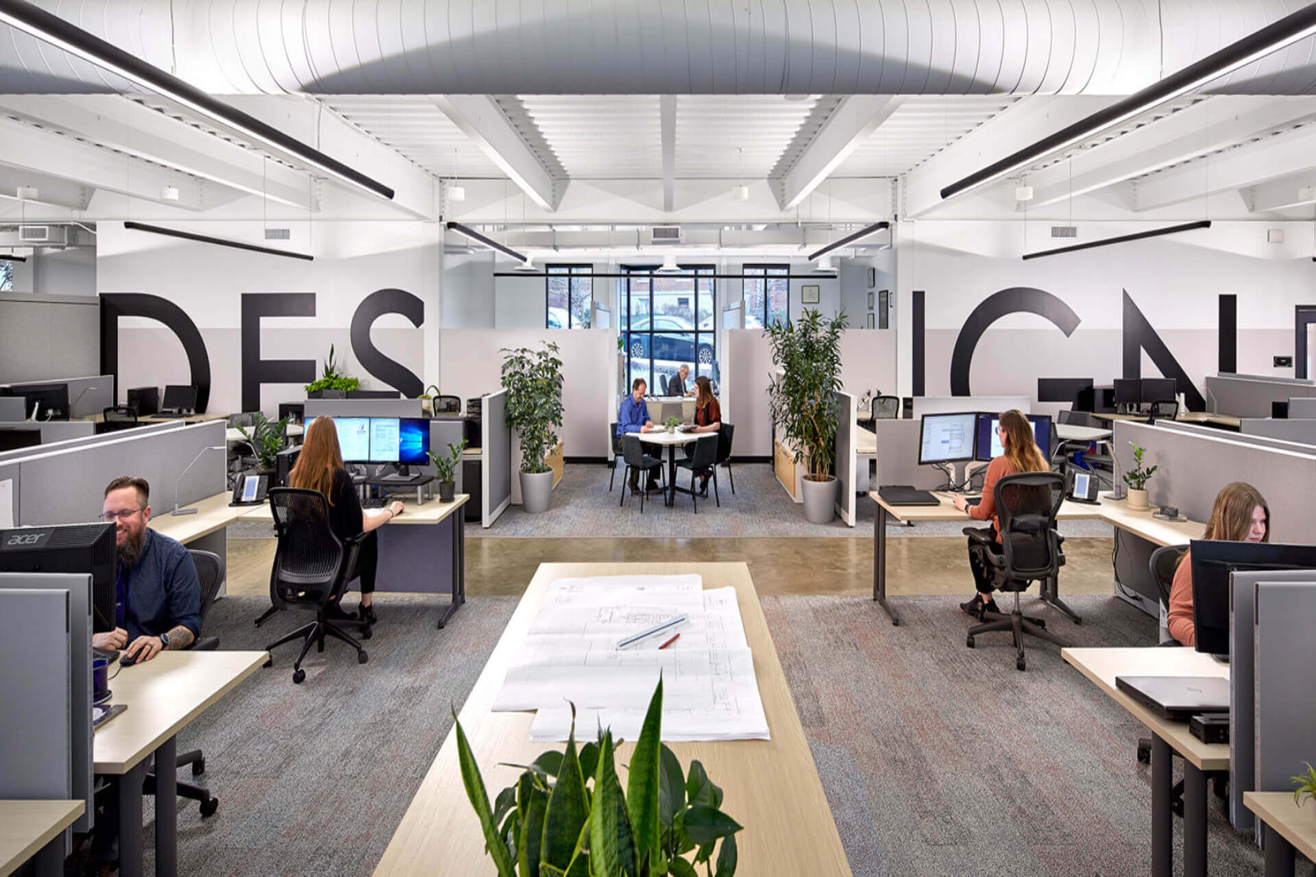 Modern office space with desks, chairs, and computers in an open layout.