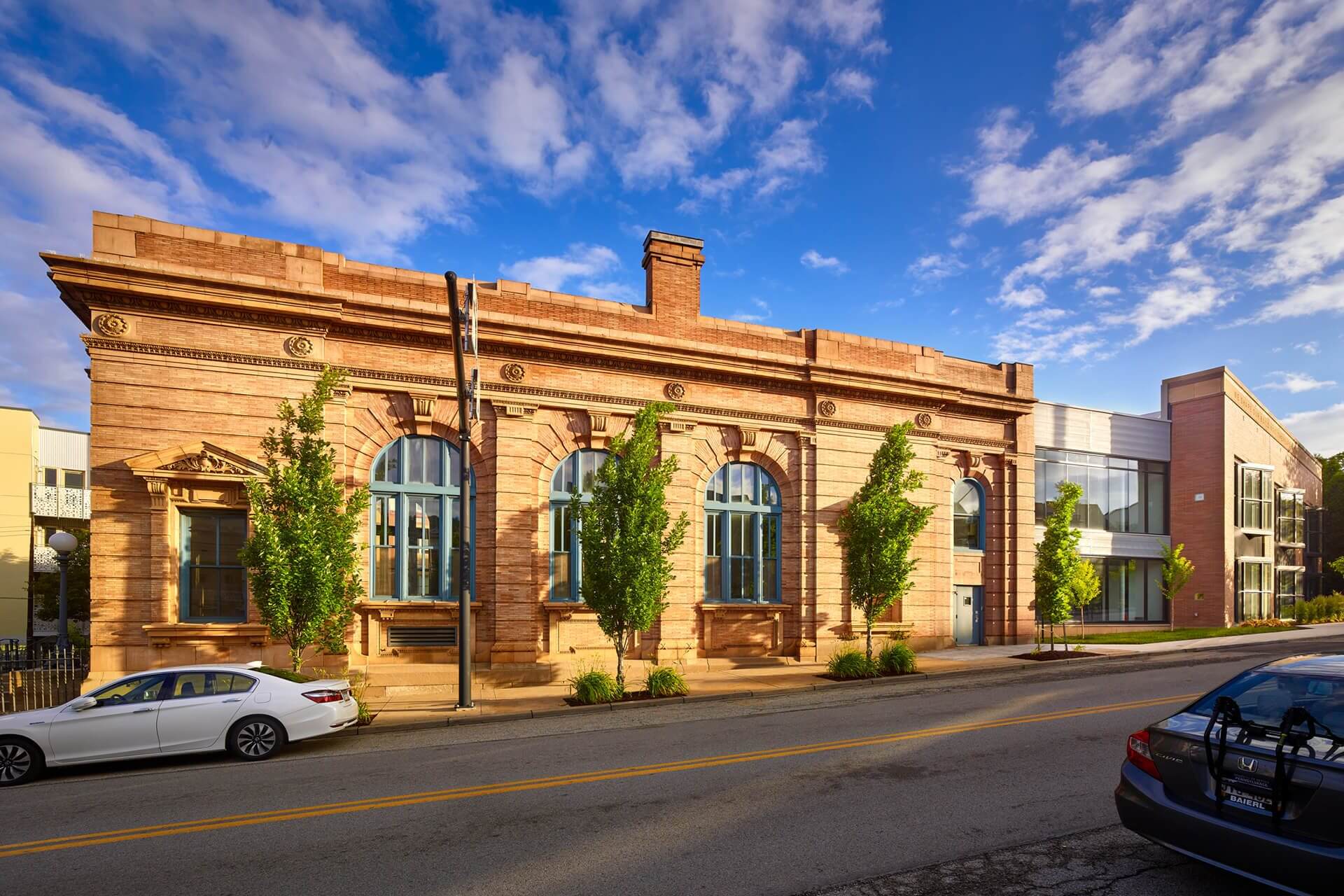 Historic brick building with arched windows under a blue sky.