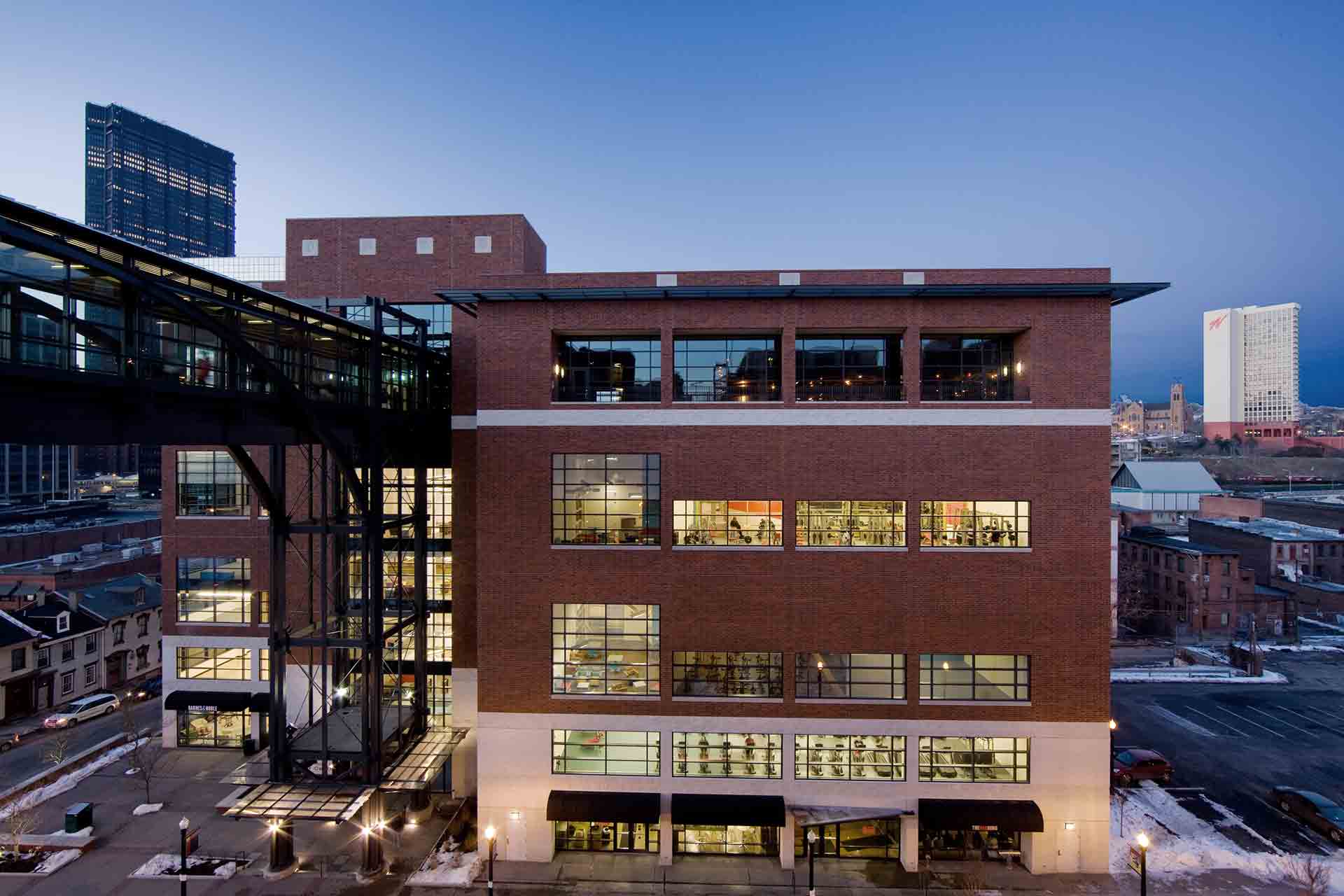 Modern brick building with large windows at dusk.