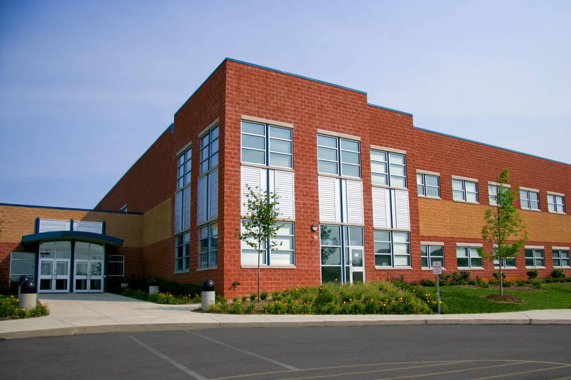 Modern red brick commercial building with large windows.