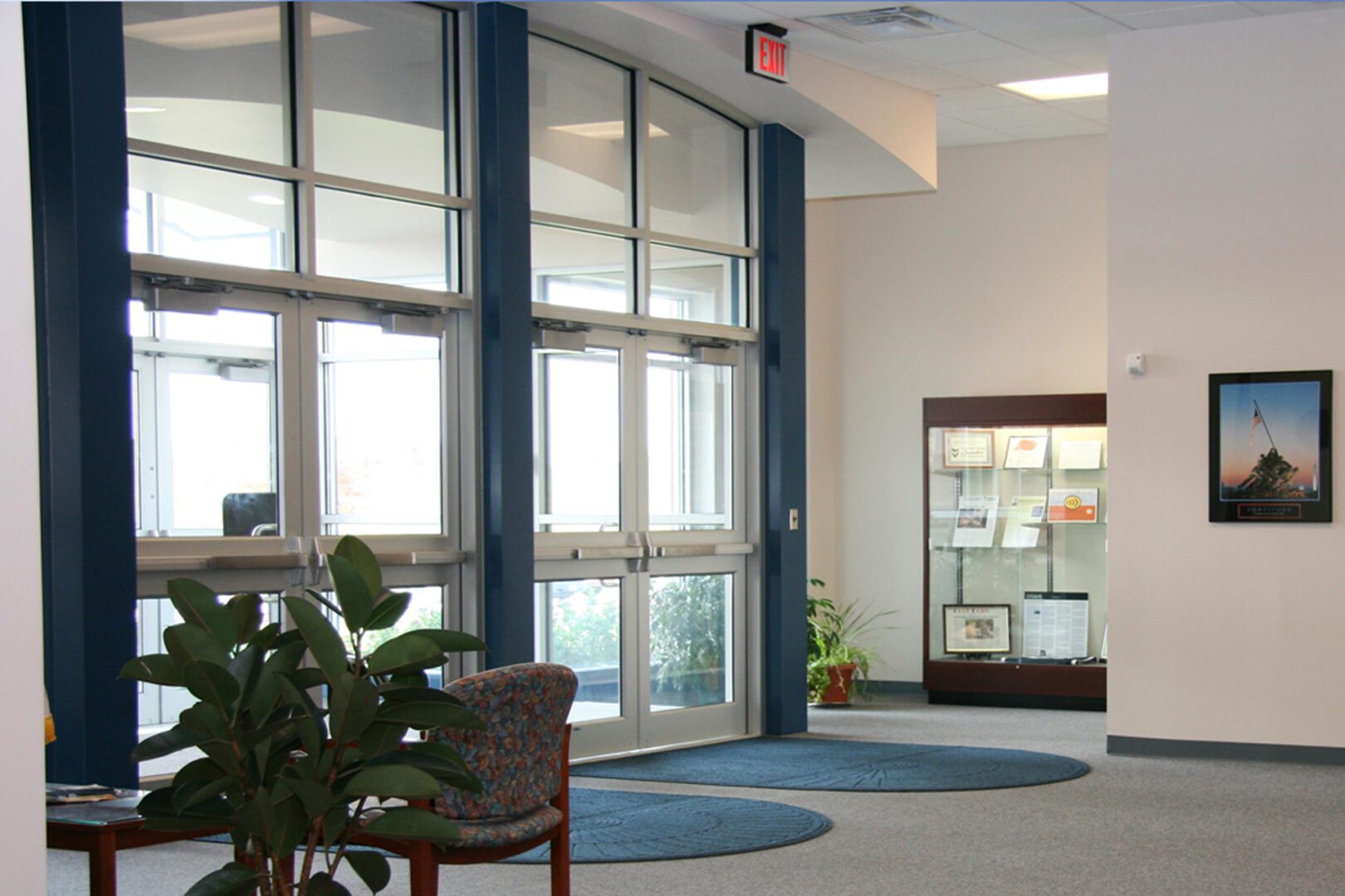A bright lobby area with glass doors and chairs.