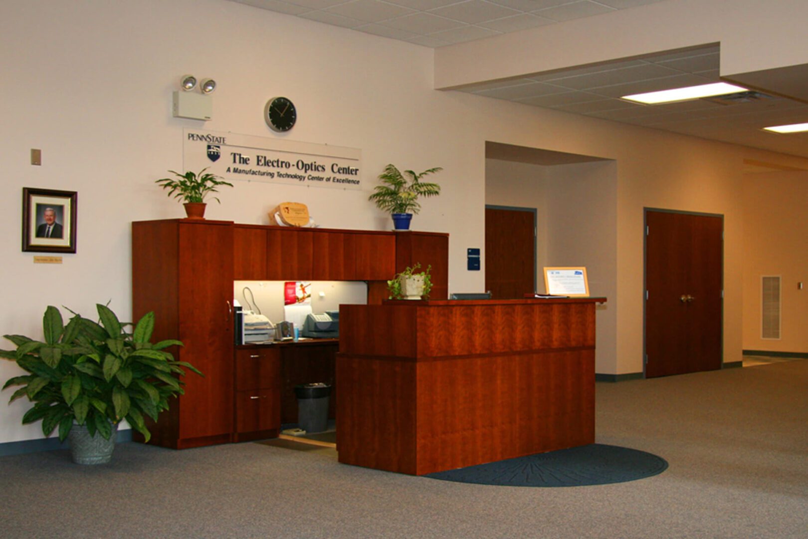 Reception area with a wooden desk and welcoming plants.