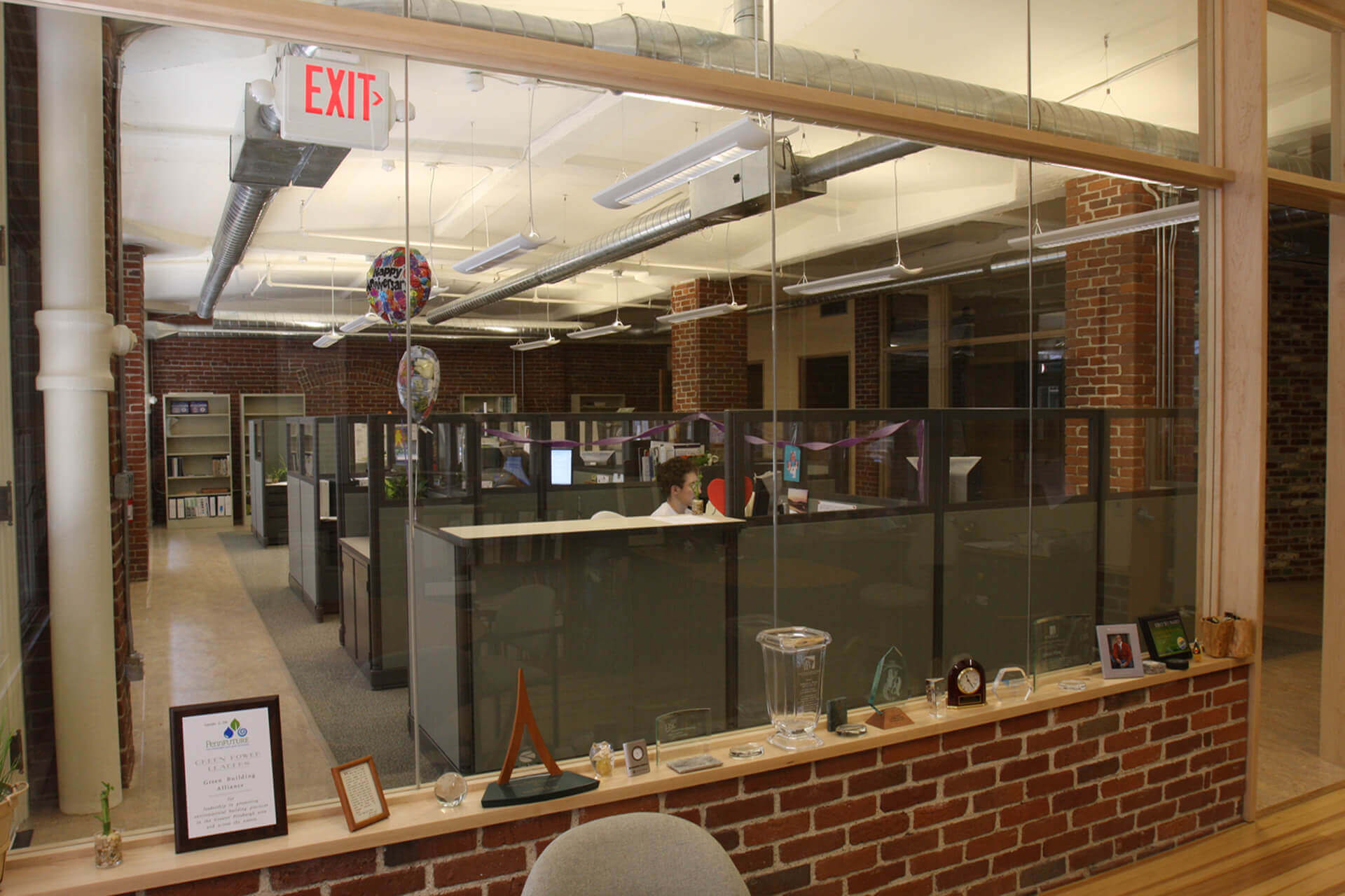 Modern office space with cubicles and exposed brick walls.
