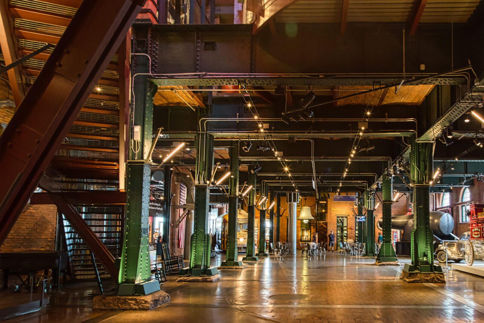 Interior of a spacious industrial-style building with metal beams and wooden floors.