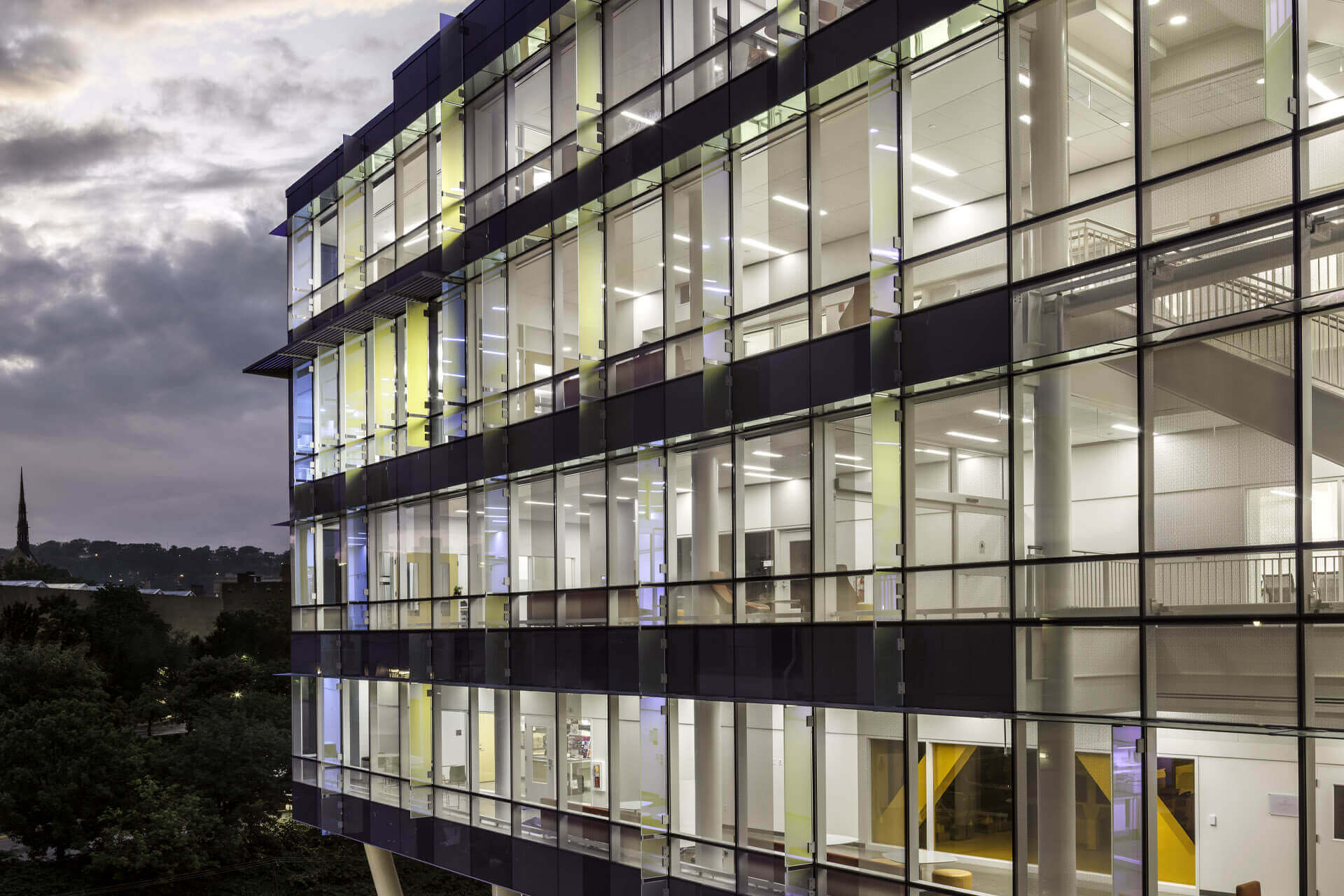 Modern office building with glass facade at dusk.