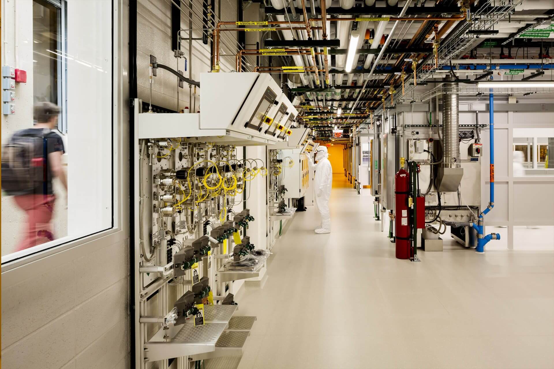 A clean, organized industrial corridor with pipes and equipment.