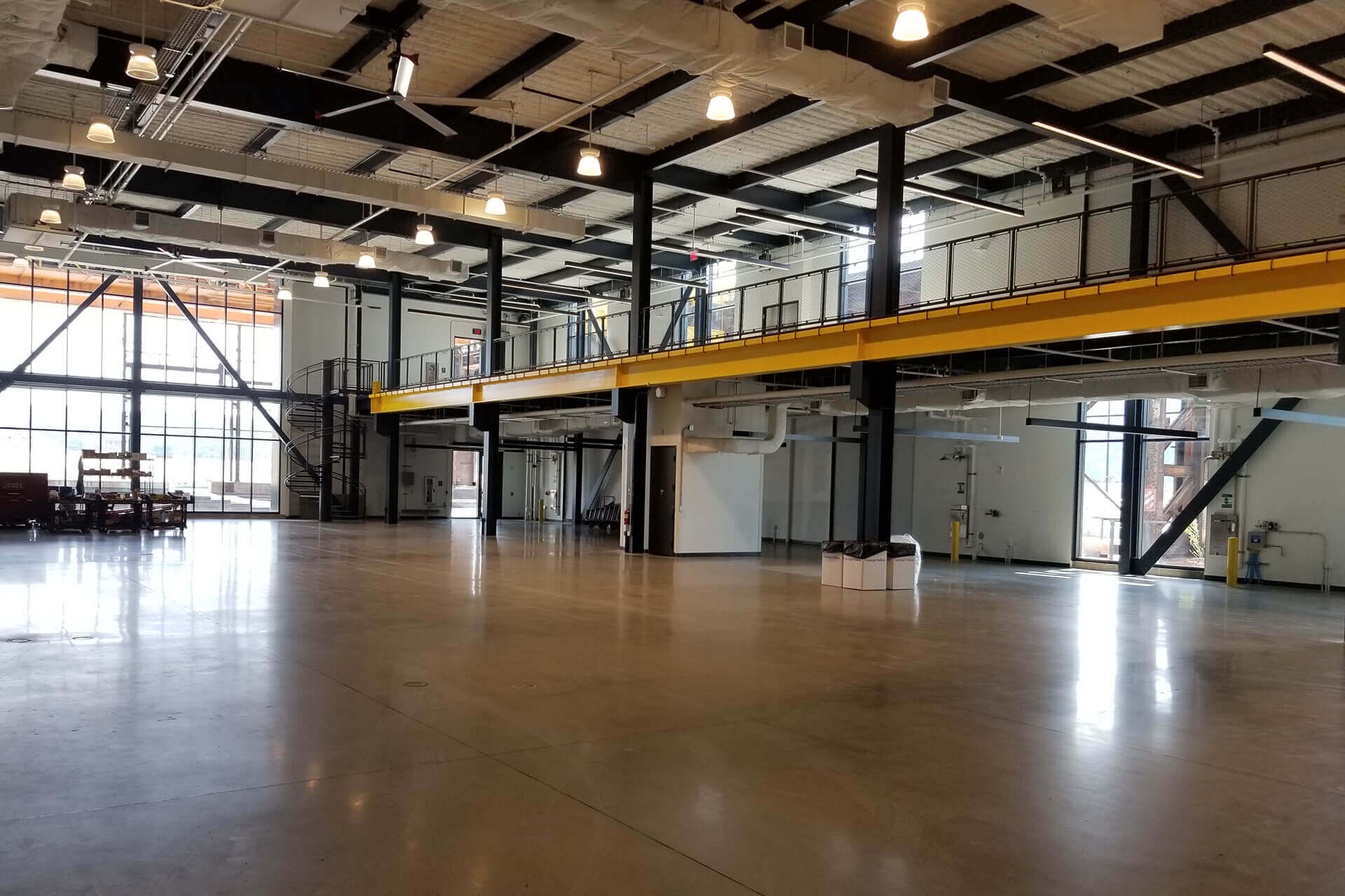 Spacious industrial warehouse interior with polished concrete floor and overhead lighting.