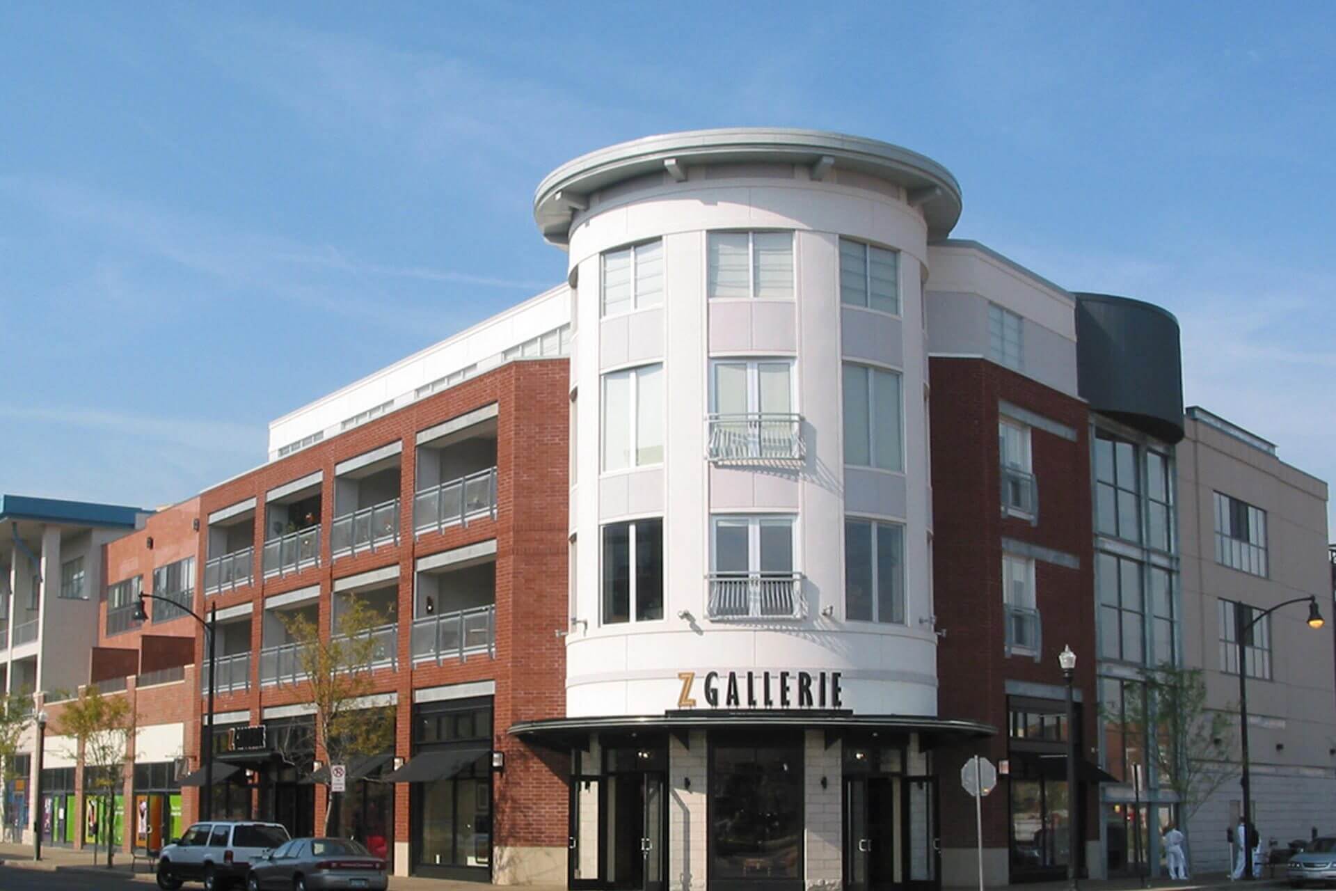 A modern three-story building with a rounded corner and large windows.