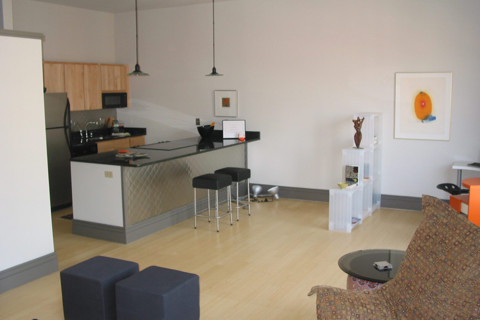 Modern kitchen with a breakfast bar and stools in a minimalist living space.