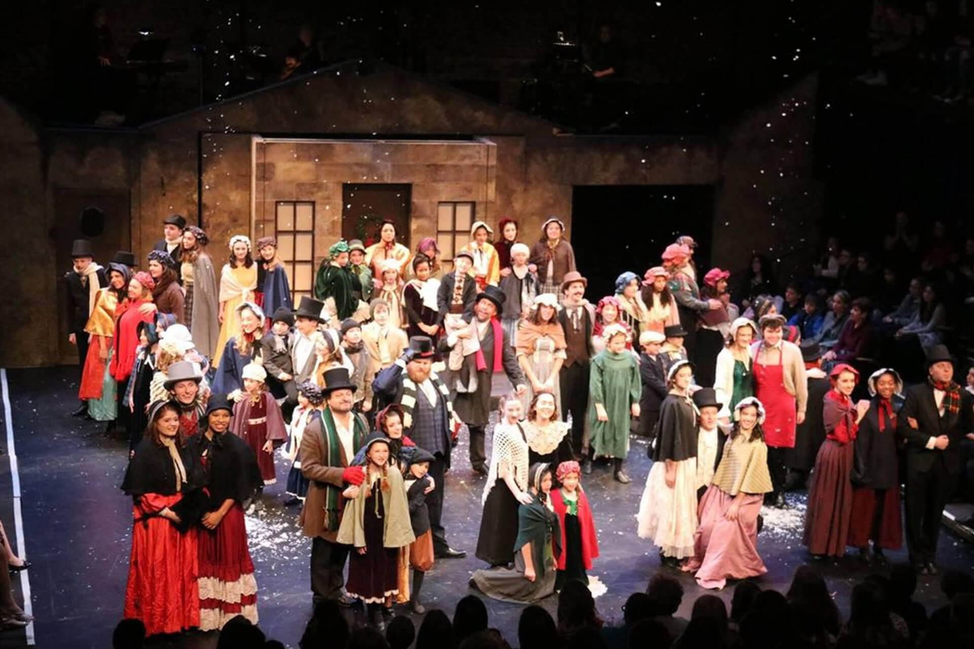 A large group in historical costumes on stage.