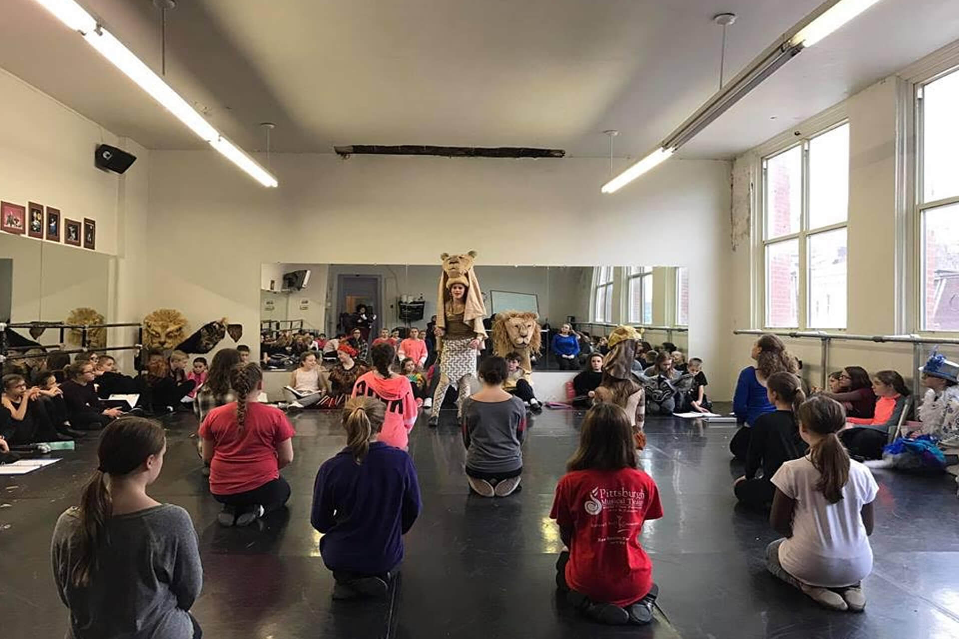 A group of children practicing martial arts in a studio.