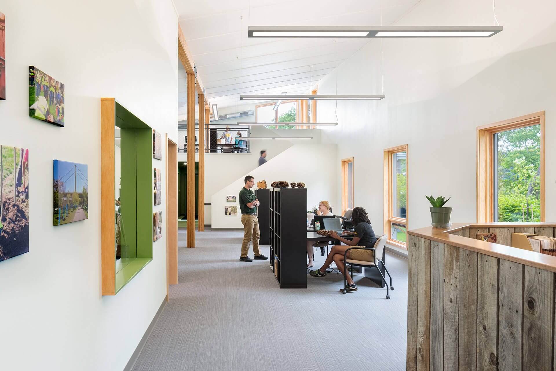 Modern office space with employees working at desks and standing.