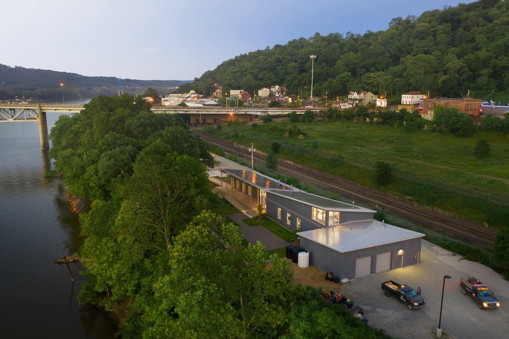 A train passing through a green, hilly area near a small town.
