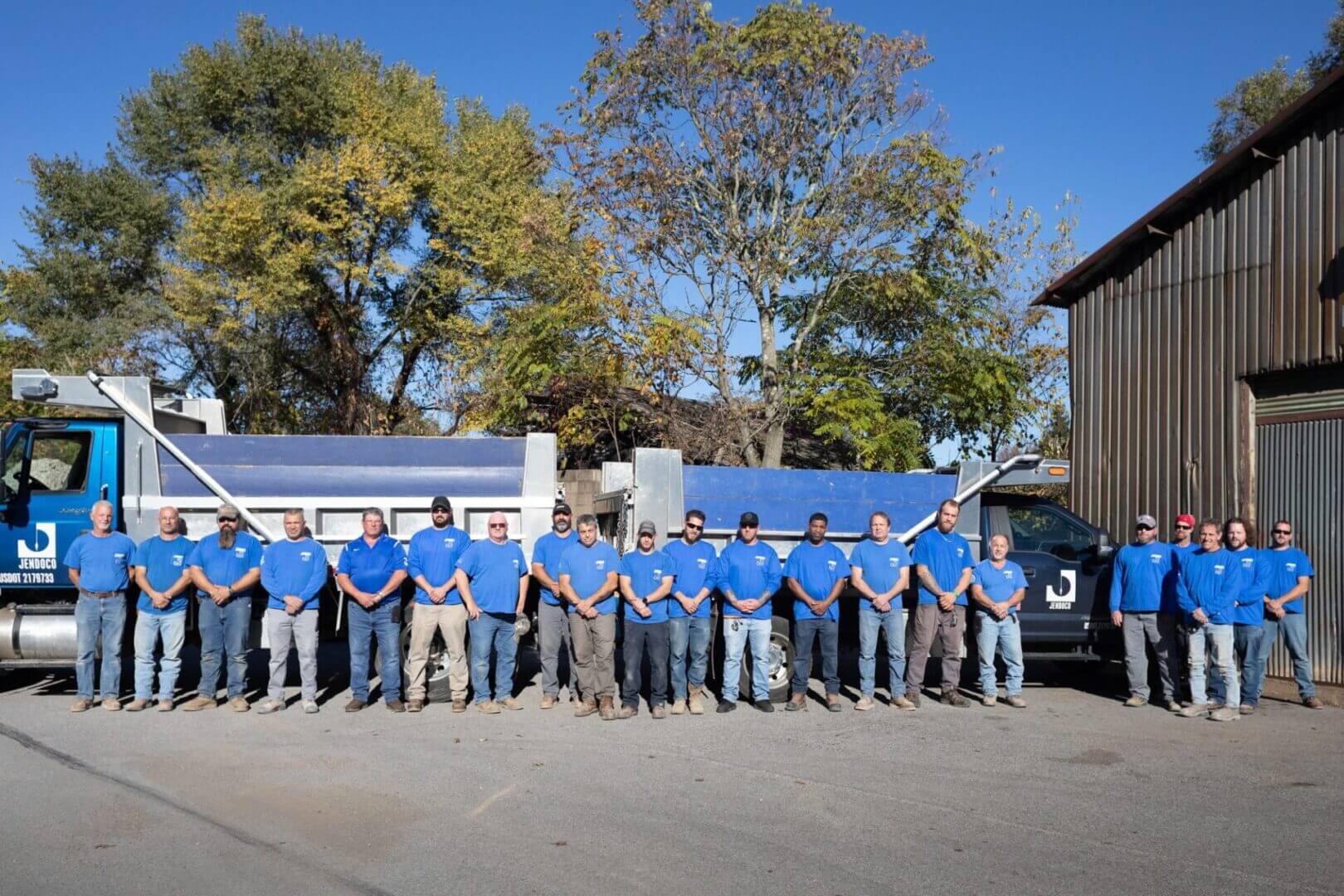 Group of workers standing in blue shirts.