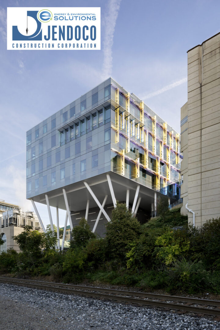 Modern building with stilts and greenery.