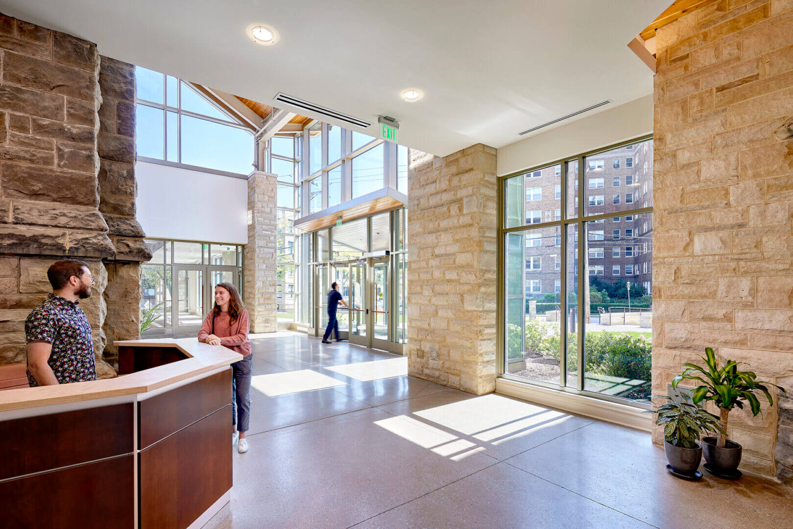 Modern building lobby with people and sunlight.