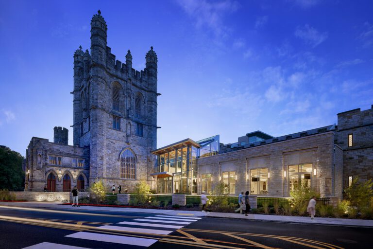 Historic building with modern extension at dusk.