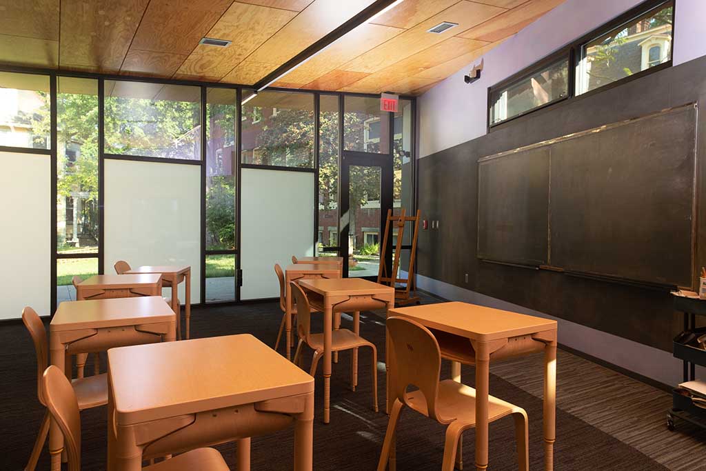 Empty classroom with wooden desks and chairs.