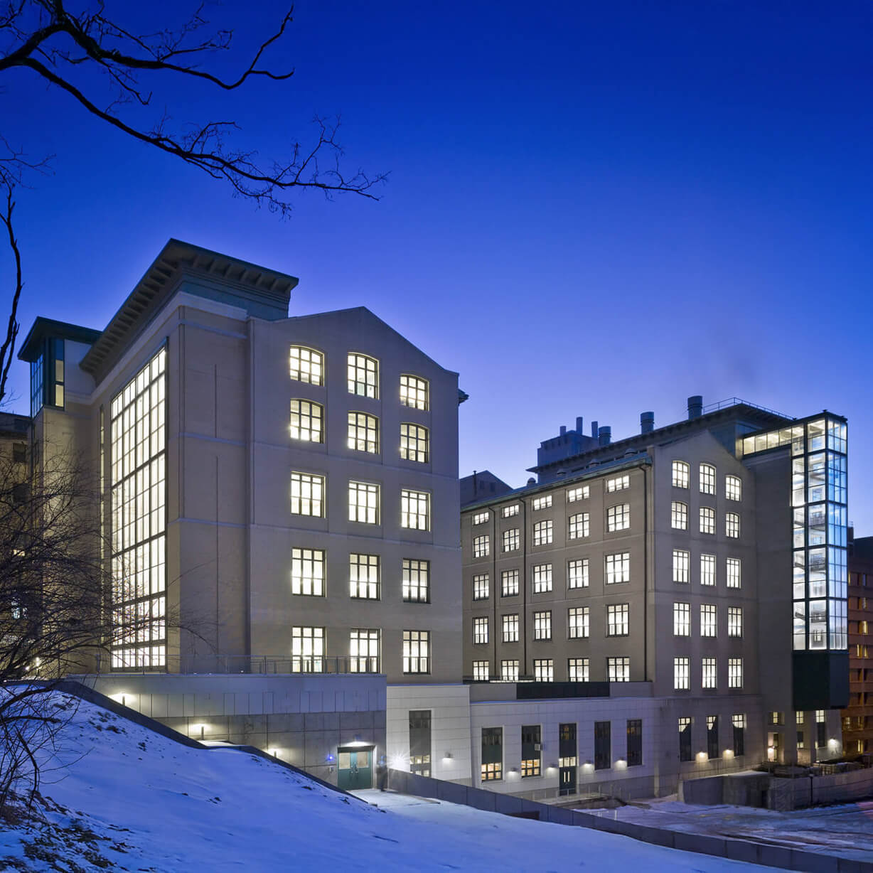 Illuminated modern buildings at twilight with snow
