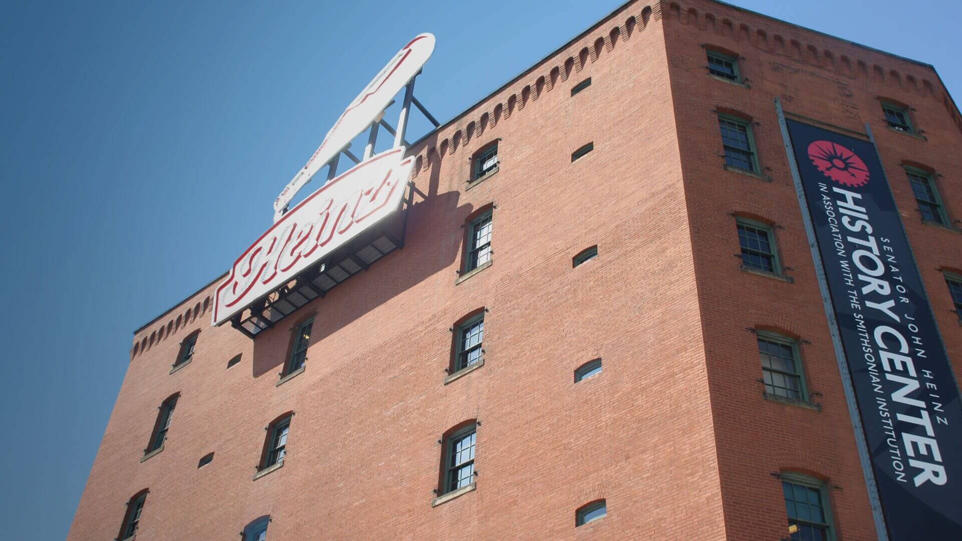 Red brick history center with rooftop sign