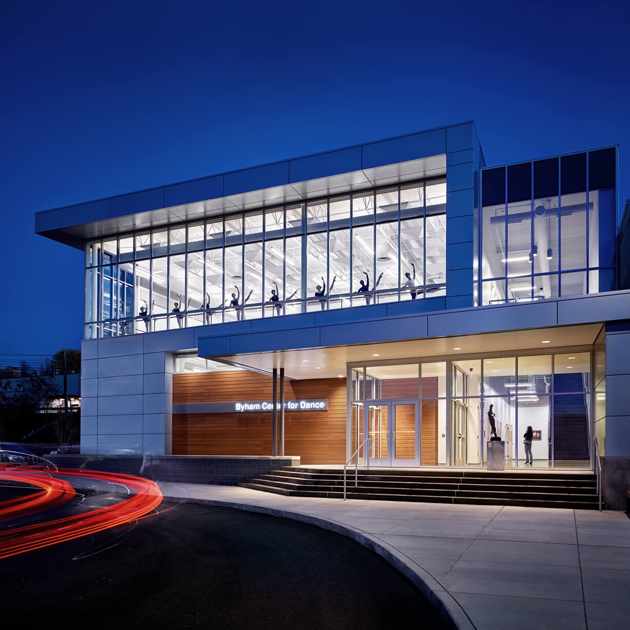 Illuminated glass dance center with dancer silhouettes