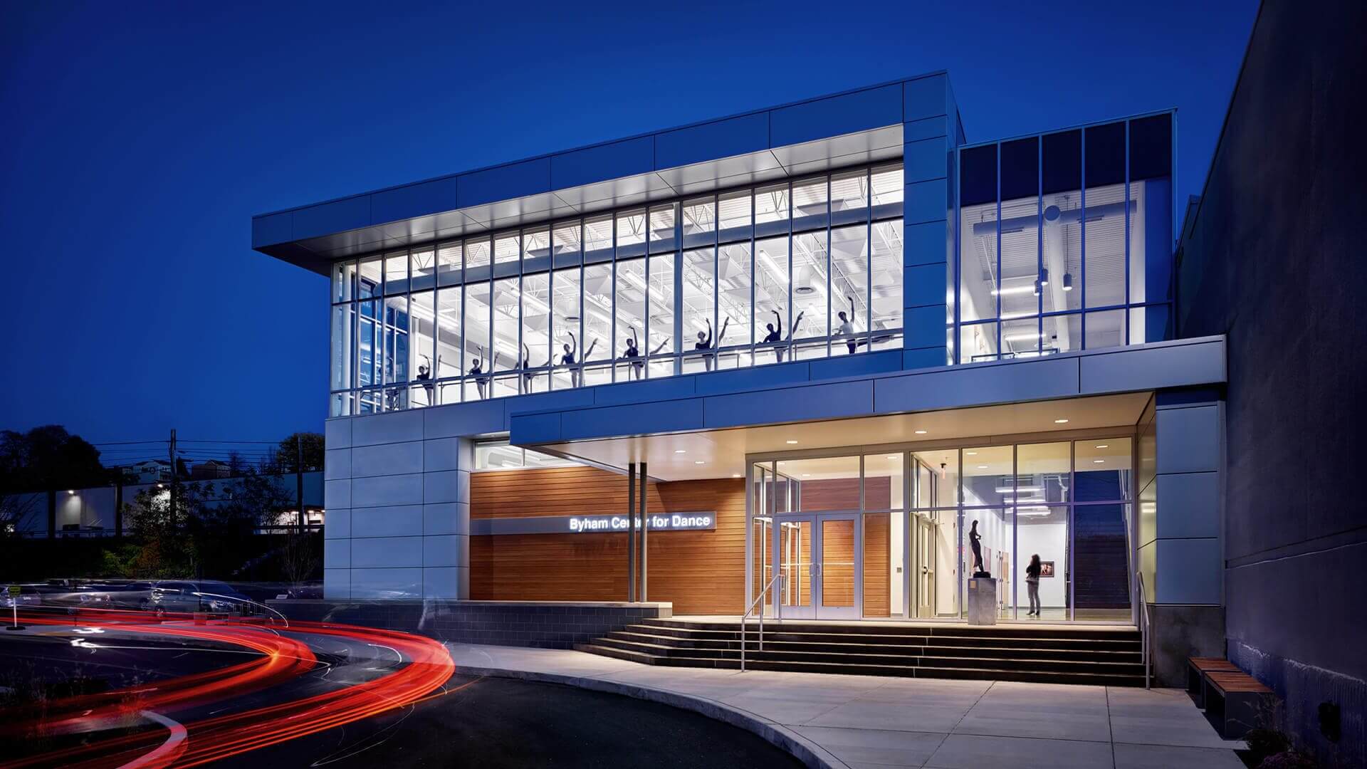 Contemporary glass-front building entrance lit at night