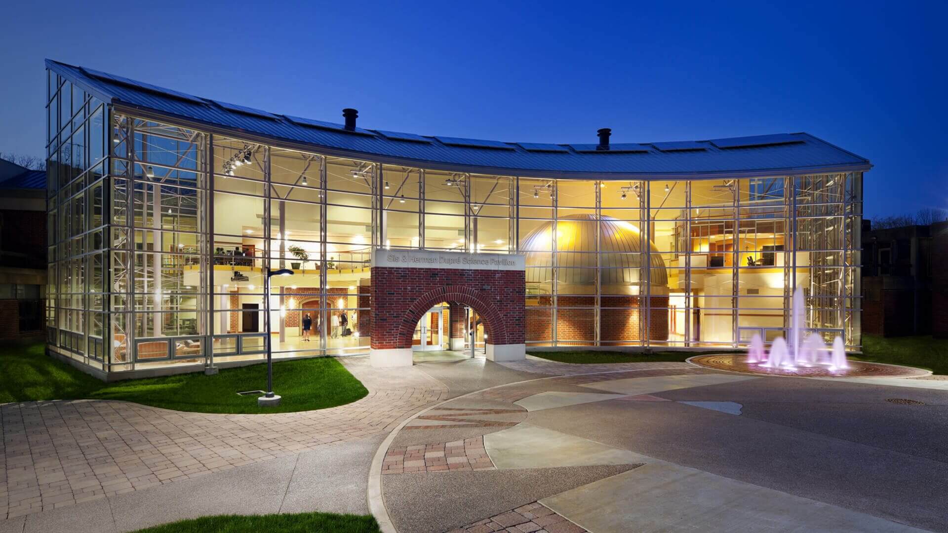 Curved glass building with illuminated interior dome