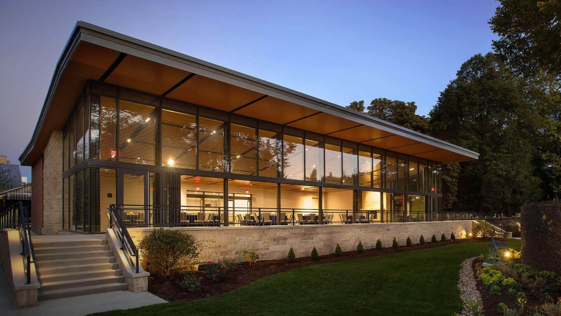 Modern glass pavilion with warm interior lighting