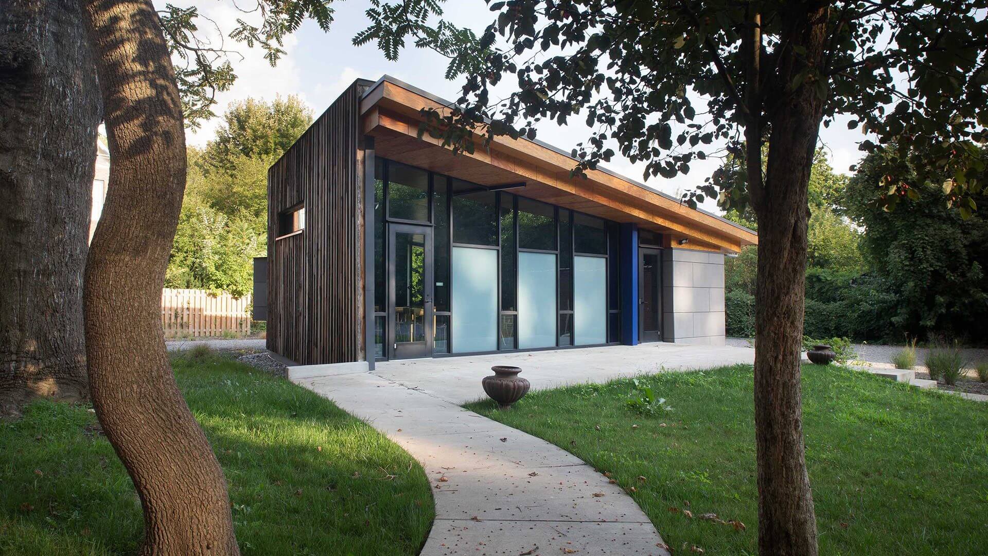 Modern glass-front studio by curved garden path
