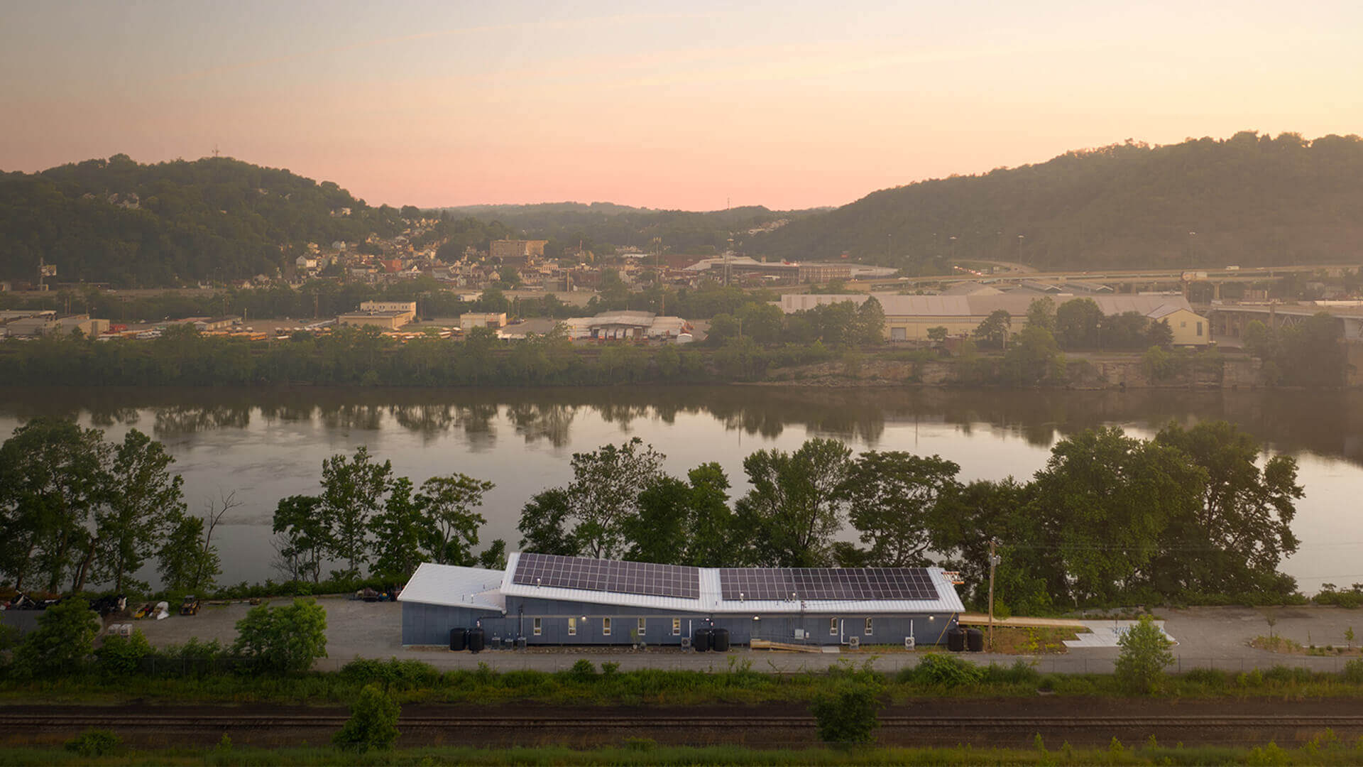 Riverside building with rooftop solar at sunset