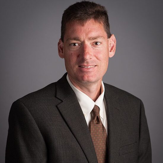 Man in suit with a neutral expression.
