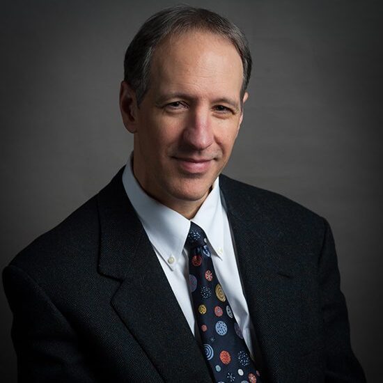 Man in suit with space-themed tie.