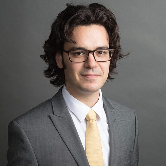 Man in suit with glasses and tie.