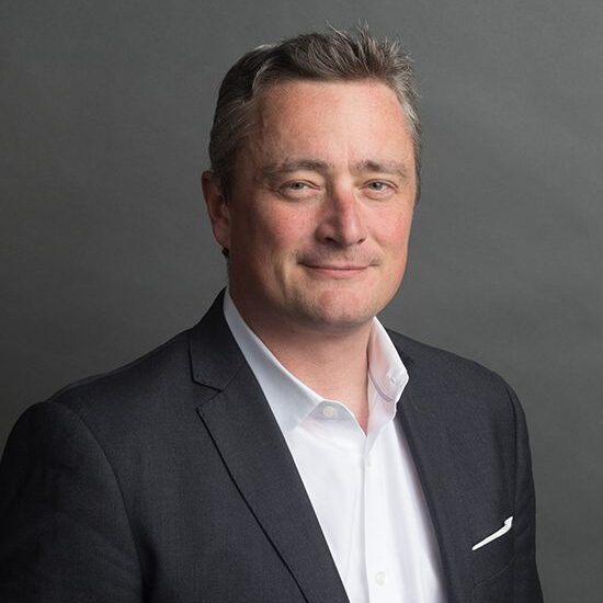 Man in suit with neutral expression.