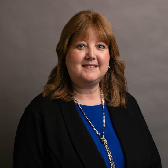 Woman smiling in professional attire.
