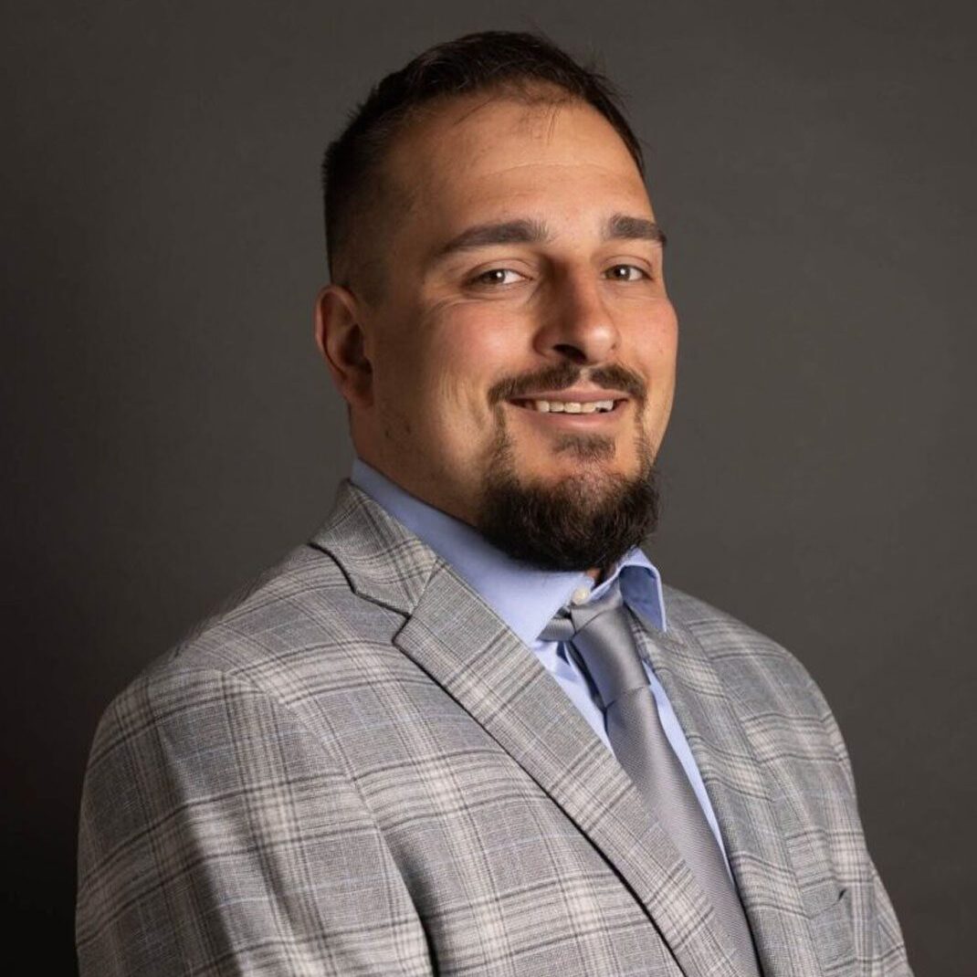 Smiling man in gray plaid suit and tie