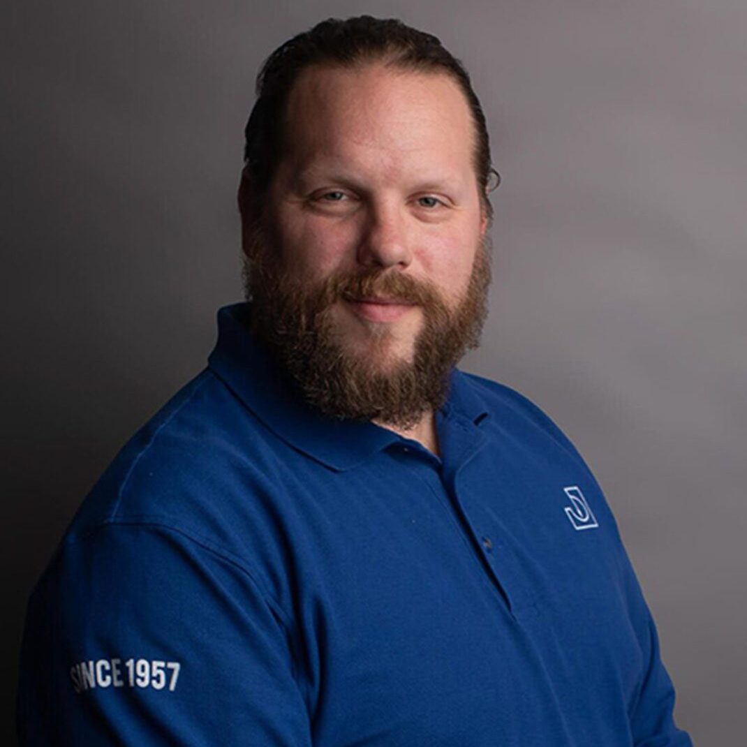 Bearded man smiling in blue polo
